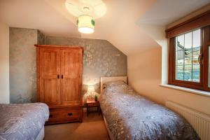 a bedroom with a bed and a cabinet and a window at Beautiful Large 4 bedroom house with hot tub in West Coker