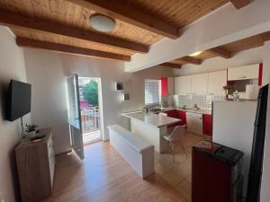 a kitchen with red and white cabinets and a refrigerator at Apartman Delnice Park Srna in Delnice