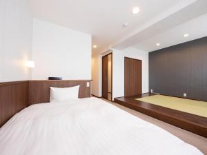 A bed or beds in a room at Tabist Hotel New Washington Shibuya