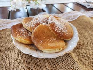 drei Donuts auf einem weißen Teller auf einem Tisch in der Unterkunft Li Brilli in Felline