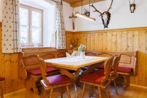 a dining room with a wooden table and chairs at Steinbergalm in Ruhpolding