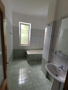 a bathroom with a sink and a tub and a toilet at Vila Cristal Costinesti in Costinesti +63 photos