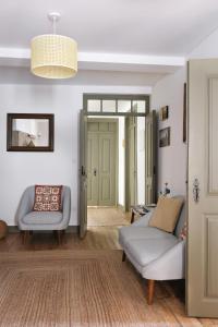 a living room with two chairs and a couch at Casa da Praça - Guest House in Pinhel