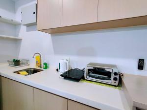 eine Küchentheke mit Mikrowelle und Spüle in der Unterkunft 20 BukitJalil Pavilion - 2bedroom - HighFloor - 吉隆坡 in Kuala Lumpur