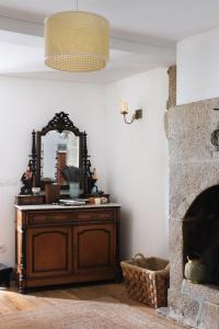 a room with a mirror and a dresser with a fireplace at Casa da Praça - Guest House in Pinhel