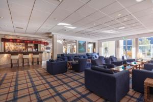 a hotel lobby with blue chairs and a bar at Hotel Loenfjord Loen in Loen