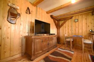 a living room with a television and a wooden wall at Cabarkapa Guesthouse in Žabljak