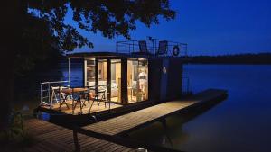 mały domek na doku na wodzie w obiekcie Domki pływające Houseboat4U, Mazury w mieście Ruciane-Nida