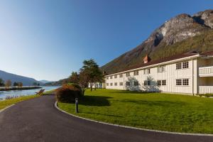 a building on the side of a road next to a mountain at Hotel Loenfjord Loen in Loen