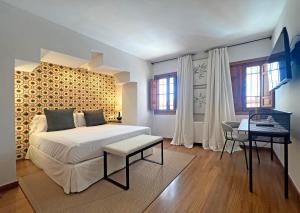 a bedroom with a bed and a table and windows at Soho Boutique Atalia in Córdoba