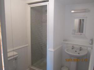 a bathroom with a shower and a sink at Cwmbach Guest House in Neath