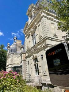 un viejo edificio con un reloj en la parte delantera en Château le Fresne, en Bouchemaine