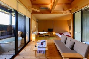 熊野市にある世界遺産リゾート　熊野倶楽部のソファ、バスタブ、ベッドが備わる客室です。