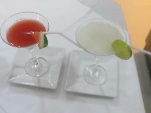 dos copas de vino con limón y una bebida en Tacuru Hotel Boutique, en Salto del Guairá