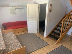 a living room with a staircase and a red couch at Mökki Uutela Taivalkoski in Taivalkoski