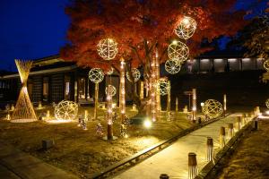 un parc avec des lumières de Noël sur les arbres la nuit dans l'établissement Resort Kumano Club, à Kumano