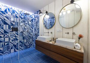 a blue and white bathroom with two sinks and a mirror at Casa Giafari in Taormina