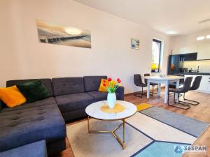 ein Wohnzimmer mit einem Sofa und einem Tisch in der Unterkunft Summer Loft Baltic 41 - 365PAM in Ustronie Morskie