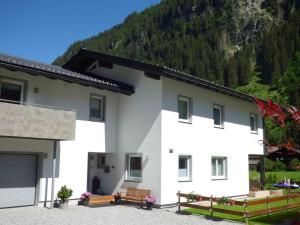 a white house with a mountain in the background at Alpenchalet Breitspitz in Partenen