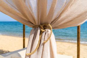 a curtain on the beach with the ocean in the background at Haus Eleonas in Kalives Poligirou