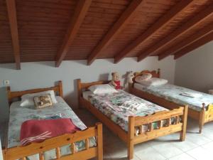 two twin beds in a room with wooden ceilings at Grecos apartment in Preveza