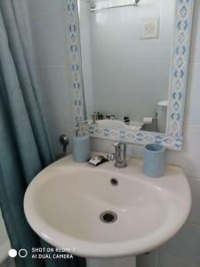 a bathroom with a white sink and a mirror at Grecos apartment in Preveza +29 photos