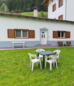 a table and chairs in the grass in front of a house at Appartment Deville with Garden in Moena