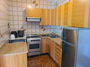 a kitchen with wooden cabinets and a stainless steel refrigerator at Appartment Deville with Garden in Moena