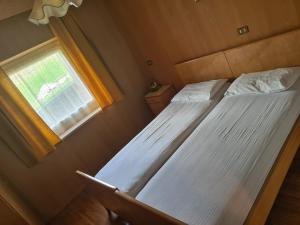 two beds in a small room with a window at Appartment Deville with Garden in Moena