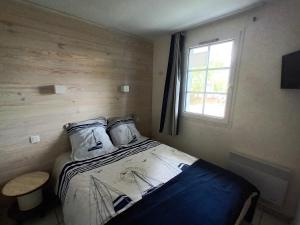 a small bedroom with a bed and a window at Port Bourgenay - Village P&V in Talmont