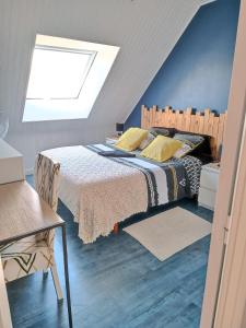 Schlafzimmer mit einem großen Bett und einem Dachfenster in der Unterkunft Chambre chez l'habitant in Châteaubriant
