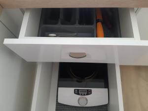 a drawer in a cabinet with a device in it at Malūno vilos studio in Palanga