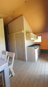 een onafgemaakte kamer met een keuken en een tafel en stoelen bij BG Apartments Safaritent in Somogyhatvan