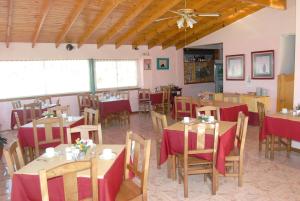 a dining room with tables and chairs and a ceiling at Hotel Fantilli in Puerto Madryn
