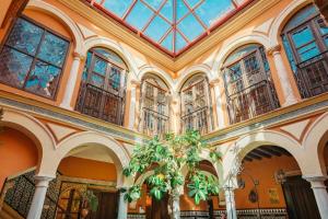コルドバにあるLa casa del Cipres una casa con historiaの大きな窓と植物のある建物