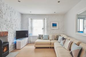 a living room with a couch and a fireplace at Chance Cottage in St Ives