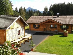 une cabane en rondins avec bancs devant elle dans l'établissement Appartements Bacherhof, à Schladming