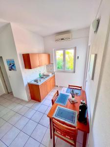 uma pequena cozinha com uma mesa e uma mesa sidx sidx em Apartments MDK Kate em Trogir