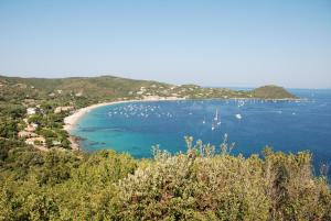 a view of a beach with boats in the water at HOTEL CAMPOMORO in Belvédère-Campomoro