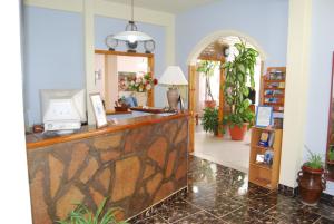 a lobby with a reception counter and a mirror at Hotel Fantilli in Puerto Madryn