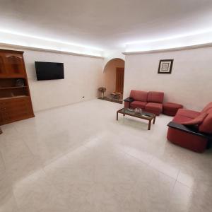Una sala de estar con dos sofás rojos y un televisor. en House with sea view/Casa con terrazzo vista mare, en Siderno Marina 16 fotos más