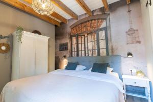 a bedroom with a large bed and a large window at B&B The Wellness Cottage in Dordrecht