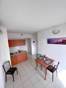 uma sala de estar com mesa e cadeiras e uma cozinha em Apartments MDK Kate em Trogir