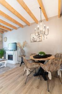 a dining room with a table and chairs and a chandelier at B&B The Wellness Cottage in Dordrecht