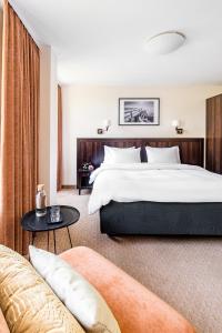 um quarto de hotel com uma cama grande e um sofá em Kerpė Hotel & SPA em Palanga