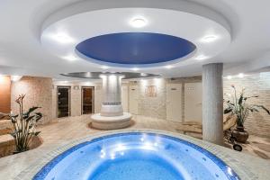 a large bathroom with a large blue tub in a room at Kerpė Hotel & SPA in Palanga