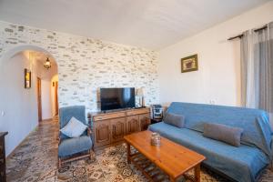 a living room with a blue couch and a tv at Cortijo Vélez in Trapiche