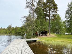 un pájaro de pie en un muelle en un lago en Cozy cottage with proximity to lake with jetty en Vimmerby
