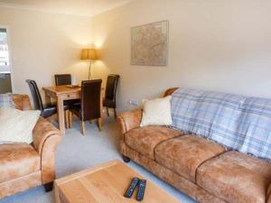 a living room with a couch and a table at Hillfoot in Kingussie