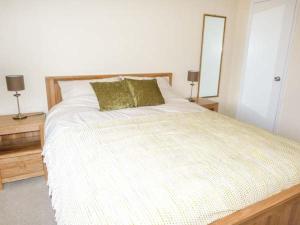 a bedroom with a bed with a mirror and two lamps at Hillfoot in Kingussie